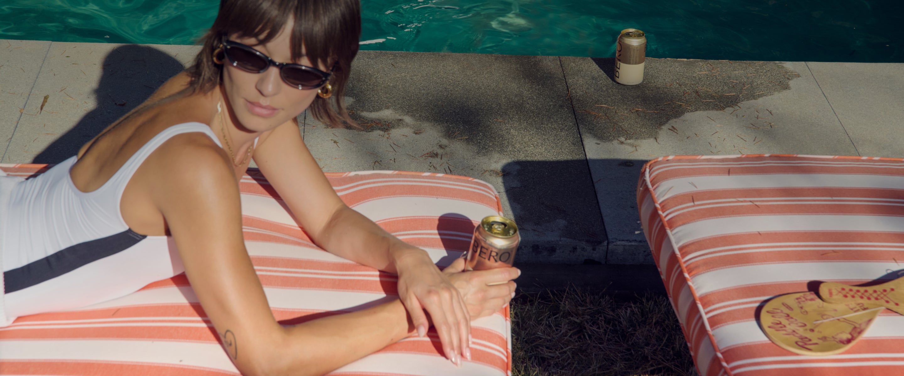 Woman laying on pool chair with can of BERO