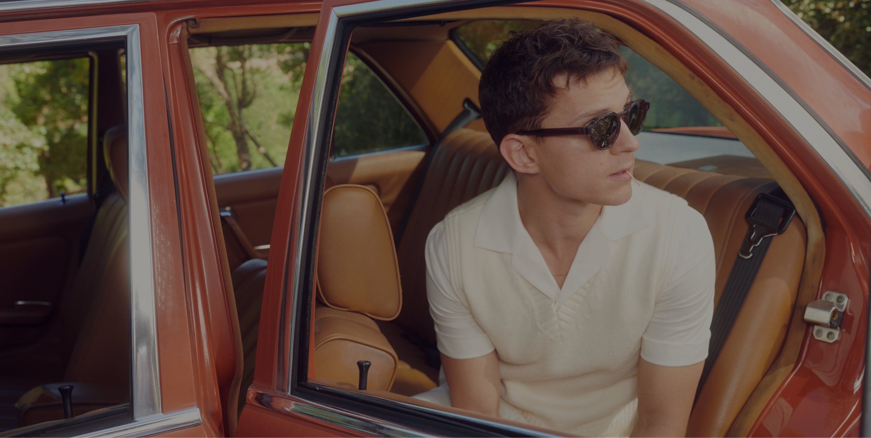 Tom inside a vintage car with sunglasses on