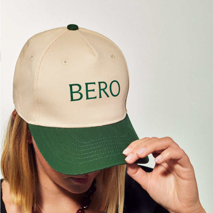 Female model with cream and green cap