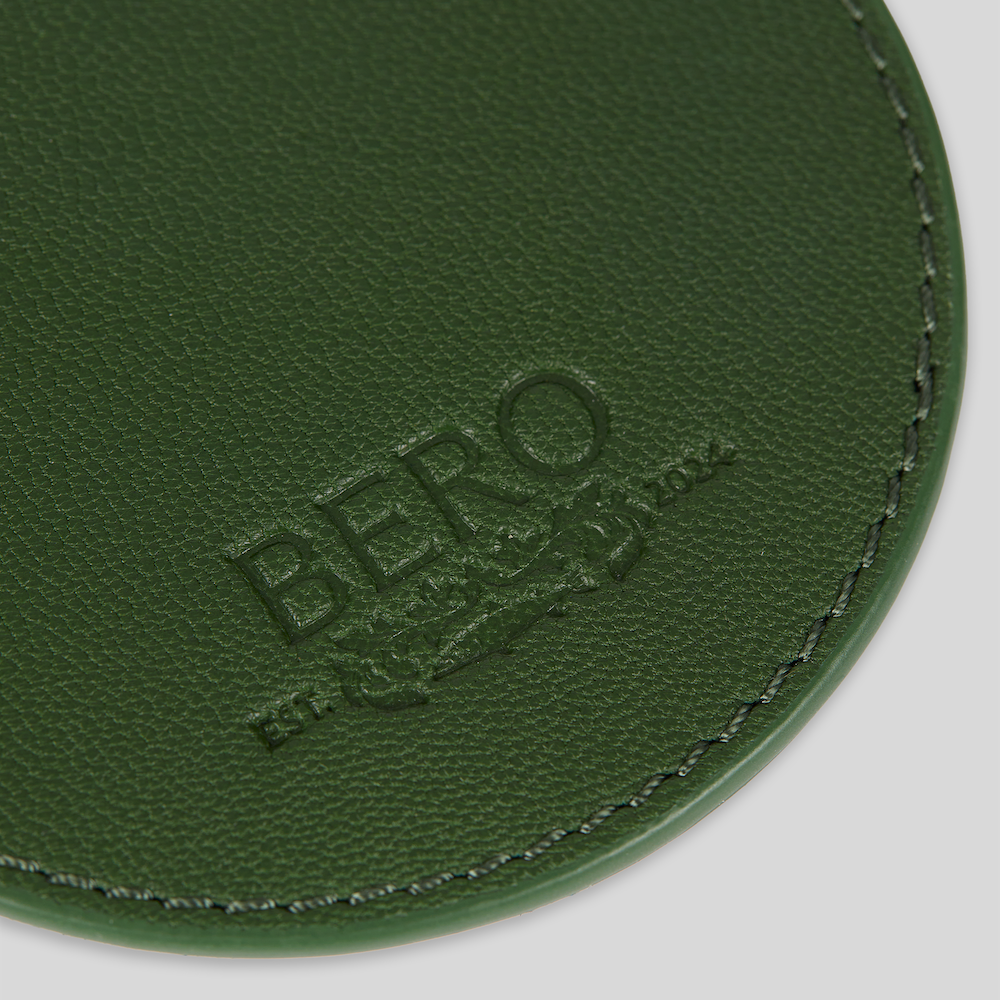 Closeup of green coaster with BERO embroidery