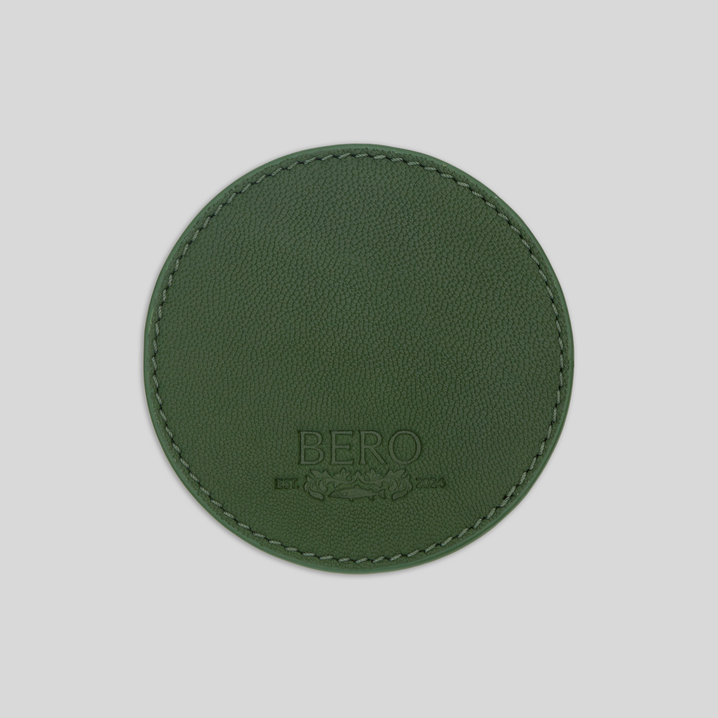 Front view of green leather coaster with BERO embroidery