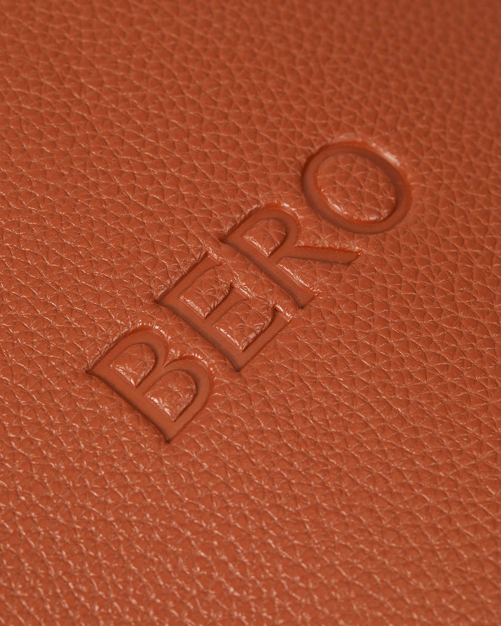 Closeup of BERO logo on leather tennis racquet cover