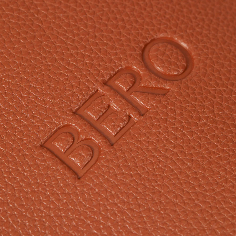 Orange textured leather surface with embossed "BERO" lettering on a tennis racquet cover