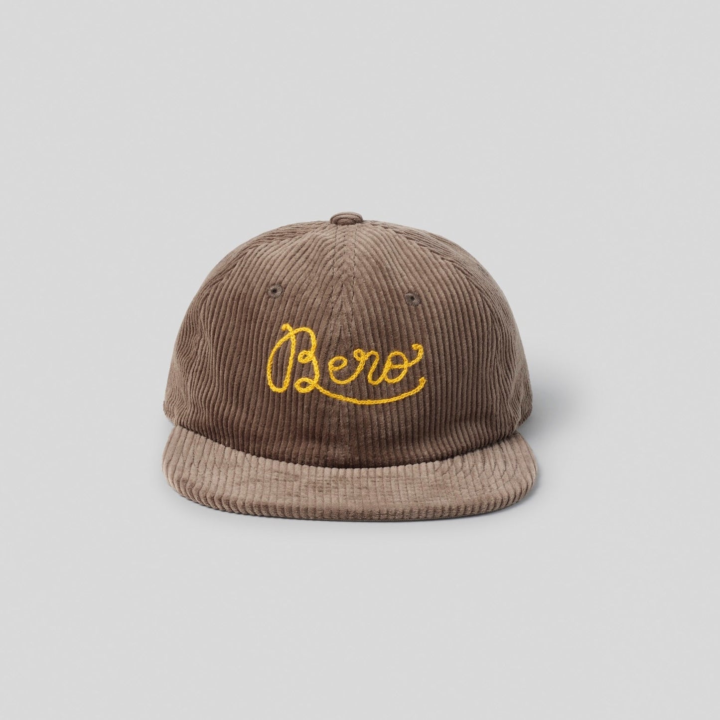 Brown corduroy cap with yellow 'Bero' logo on a light gray background