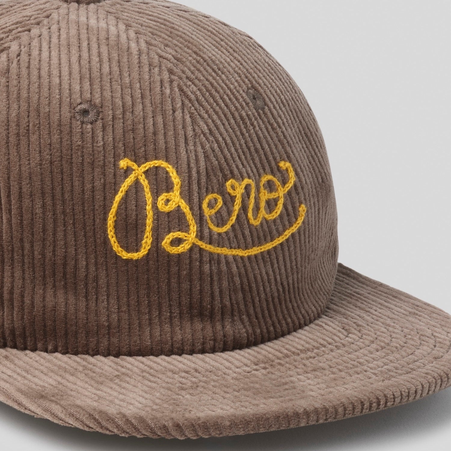 Brown corduroy cap with yellow 'Bero' embroidered on front