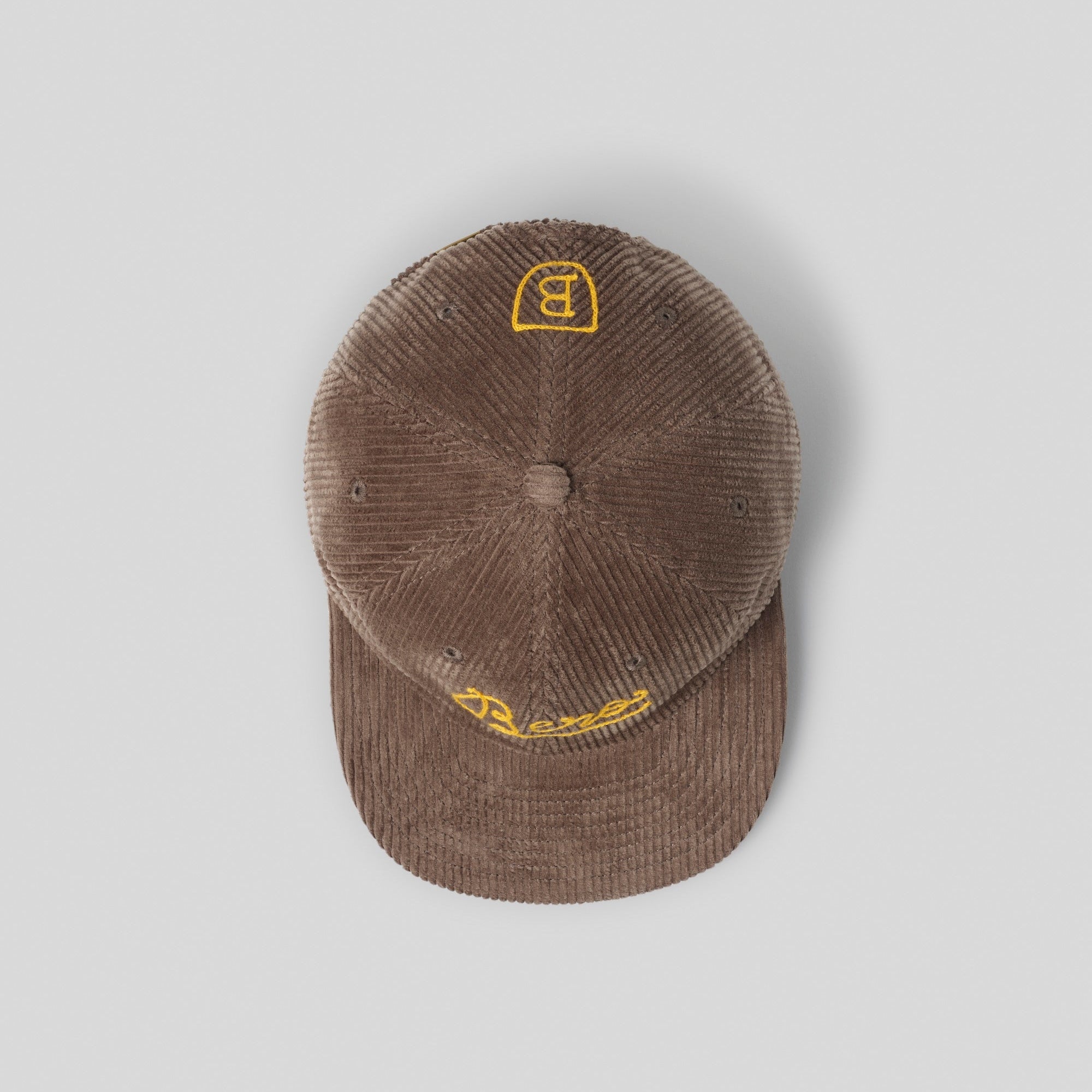 Top view of brown corduroy cap with yellow 'B' logo 