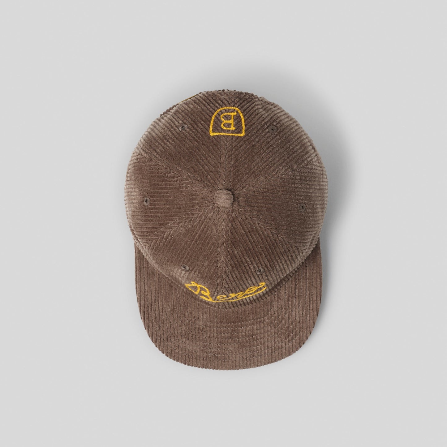 Top view of brown corduroy cap with yellow 'B' logo 