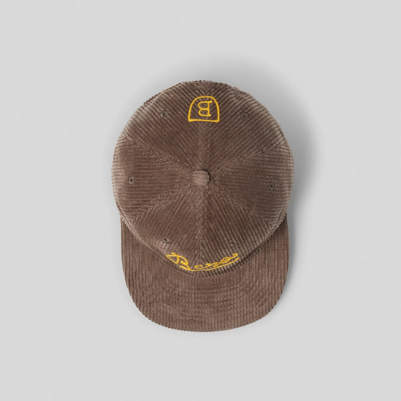 Brown corduroy baseball cap with yellow embroidered BERO logo on front and cursive text on brim, shown from above