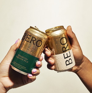 Two hands cheers-ing cans of BERO