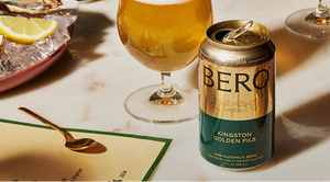 Bero Kingston Golden Pils can on a table with a glass of beer and lemon 