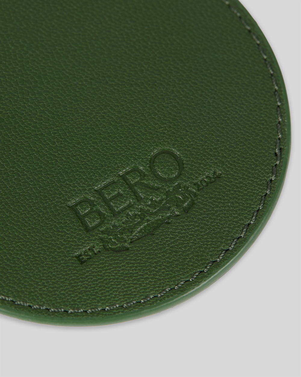Closeup of green coaster with BERO embroidery