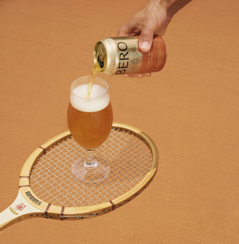 Double Tasty in a glass on top of a tennis racquet