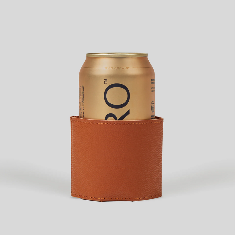 Orange leather koozie holding a gold BERO Brewing non-alcoholic beer can against a light gray background