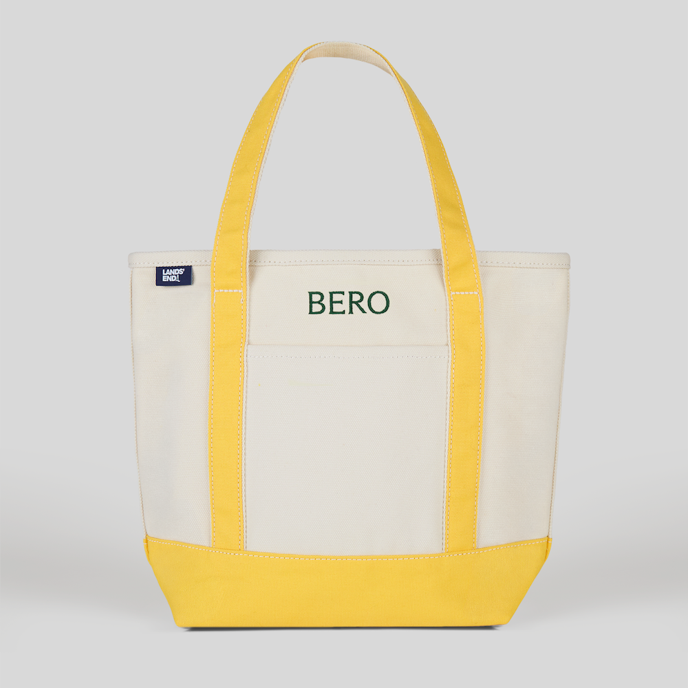 Canvas tote bag with yellow straps and beige body on a white background