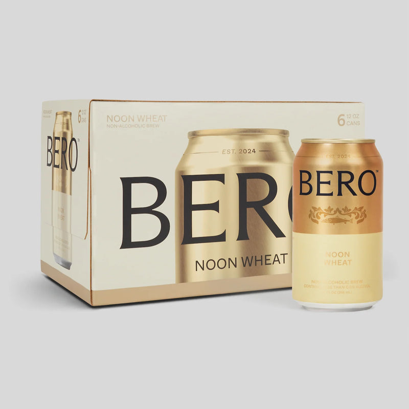 BERO Noon Wheat non-alcoholic beer 6-pack box with two golden cans displayed, featuring cream and gold packaging design