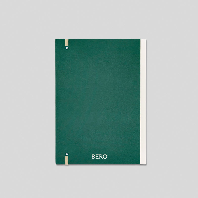 Green notebook with BERO branding and wooden binding details against light background