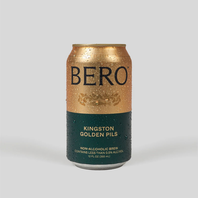BERO Kingston Golden Pils non-alcoholic beer can with gold and teal design, covered in water droplets on gray background