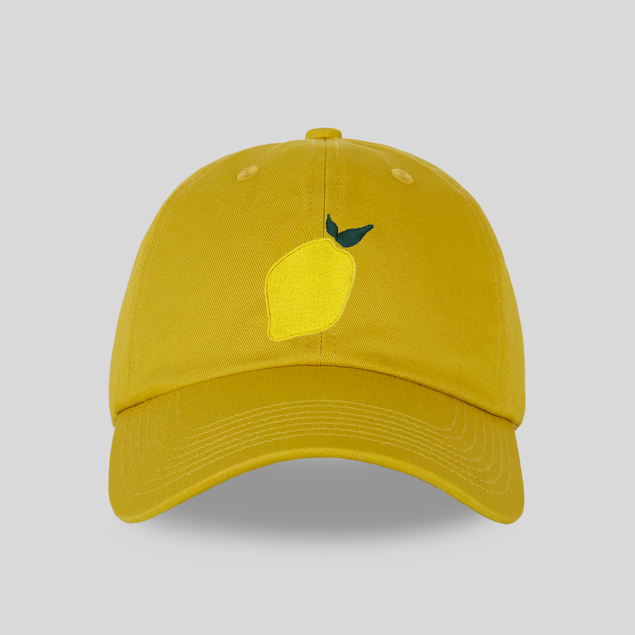 Yellow cap with a lemon design on a light gray background