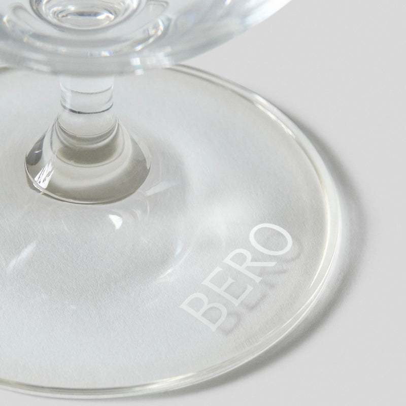 Clear glass with BERO logo etched on bottom, showing stem and base in close-up detail